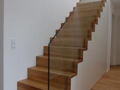 Holztreppe mit Einbauschrank und Glasgeländer 