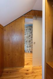 Schiebetür und holzverkleidete Wand